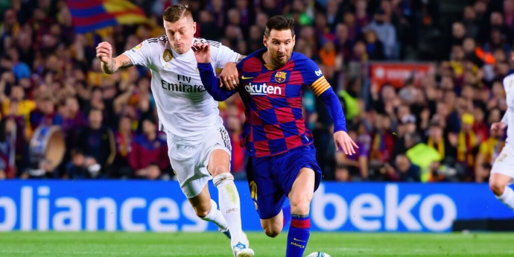 Kroos (L) and Messi (R) play at the La Liga match between FC Barcelona and Real Madrid at the Camp Nou Stadium on December 18, 2019 in Barcelona, Spain