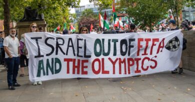 Protesters holding a banner in Manchester to remove Israel from FIFA and the Olympics