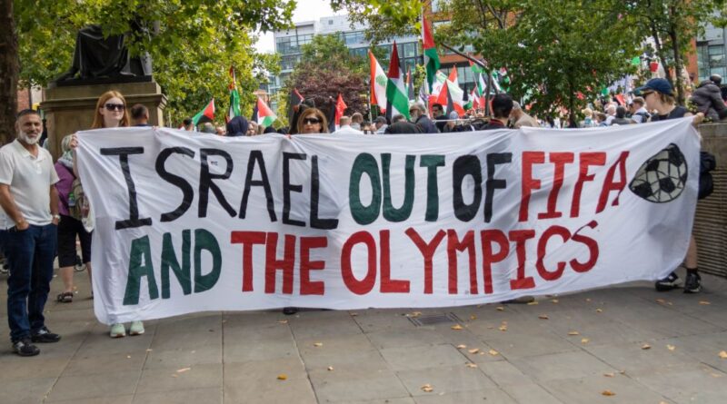 Protesters holding a banner in Manchester to remove Israel from FIFA and the Olympics